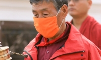 Fedele con mascherina presso lo Stupa di Bodnath, Kathmandu